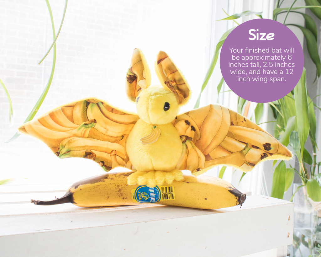 A yellow banana themed bat plush sits on top of a banana. A text overlay describes the size (available in the product description)