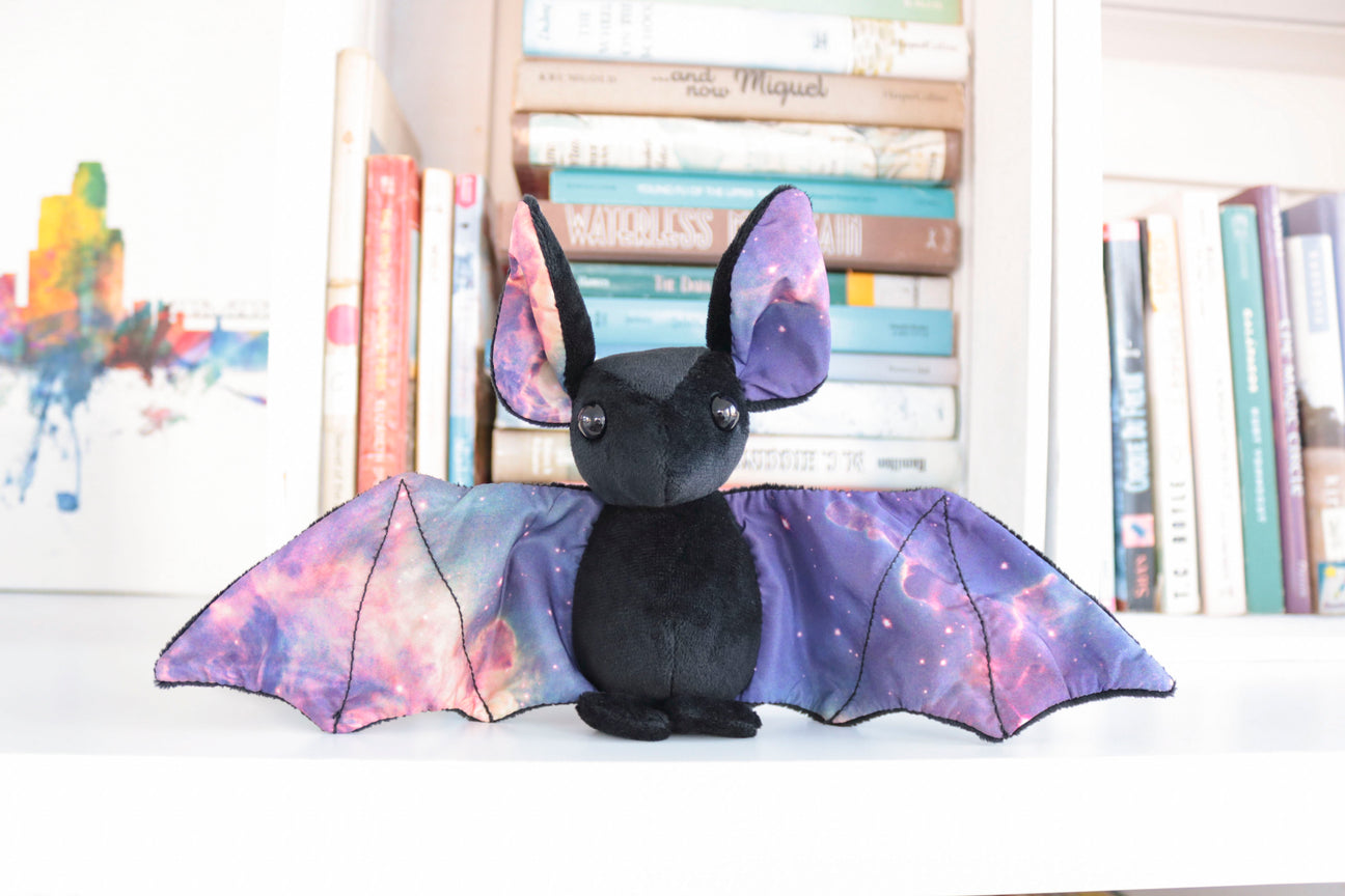 Plush toy of a black bat with galaxy patterning