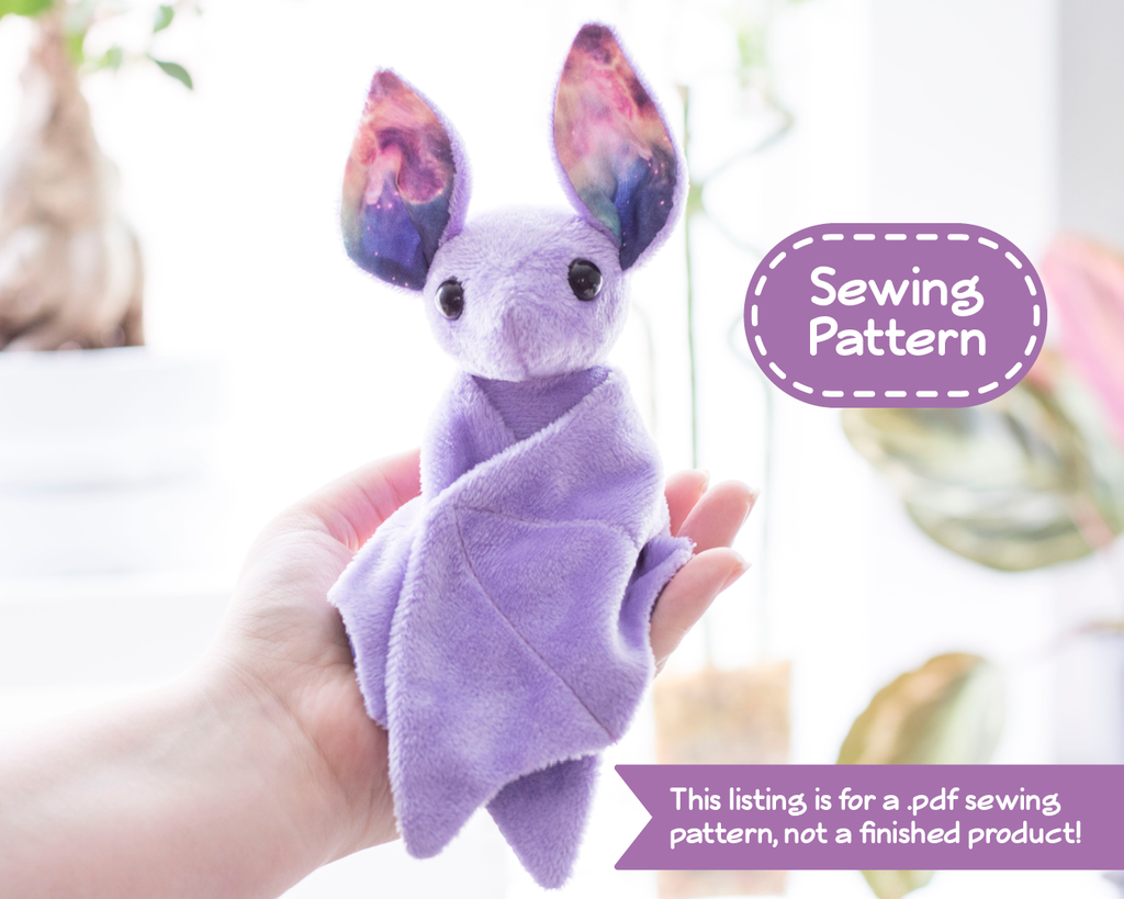 A photo of a small purple bat plush sitting in a person's hand. Overlaying the image are text bubbles reading "Sewing Pattern" and "This listing is for a .pdf sewing pattern, not a finished product!"